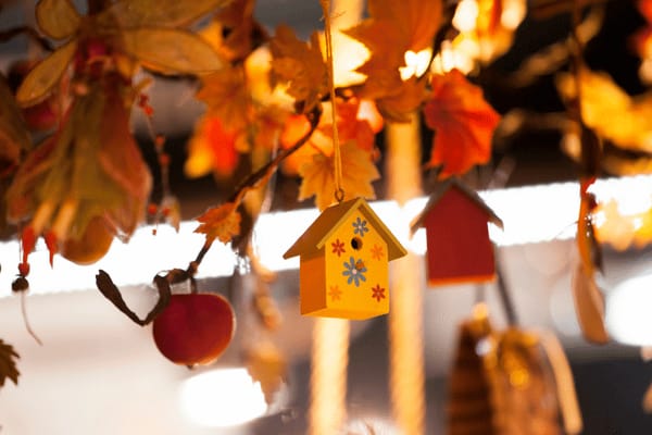 Dekoration in Form von Herbstblättern und Holzfiguren.