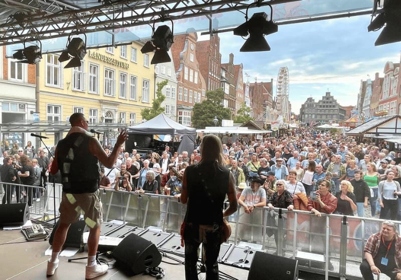 Eine Live-Band spielt vor großem Publikum auf einer Bühne beim Stadtfest Uelzen.