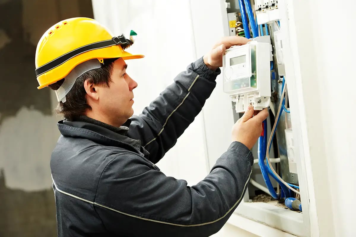 Installateur wechselt einen Stromzähler