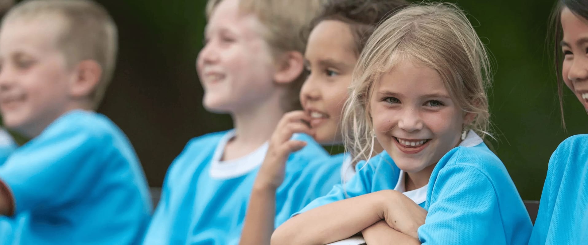 Eine Gruppe von lächelnden Kindern in blauen Triktots