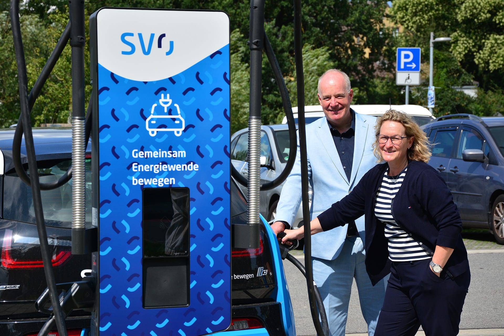 Geschäftsführer der SVO-Gruppe und Celles Stadträtin Nicole Mrotzek nehmen neue Ladesäulen in der Hafenstraße in Betrieb.