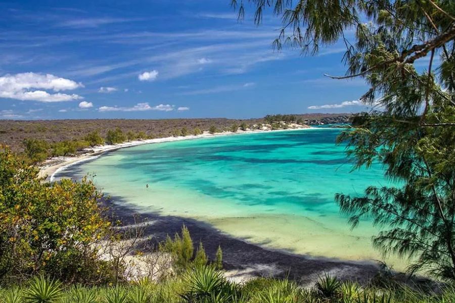 Turquoise lagoon bay with white sand beach, framed by coastal trees in Madagascar