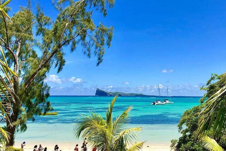 Turquoise lagoon with catamarans anchored, Coin de Mire islet visible on the horizon