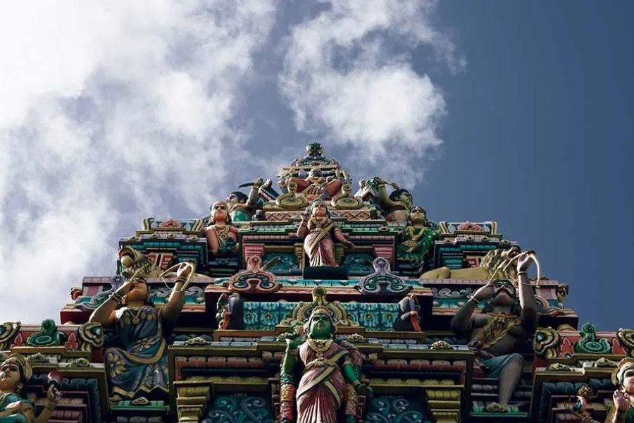 Colorful Hindu temple tower with detailed deity statues under a blue sky in Mauritius