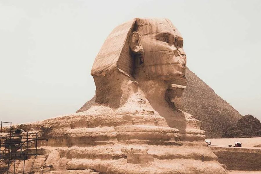 Close-up of the Great Sphinx of Giza with a pyramid visible behind it