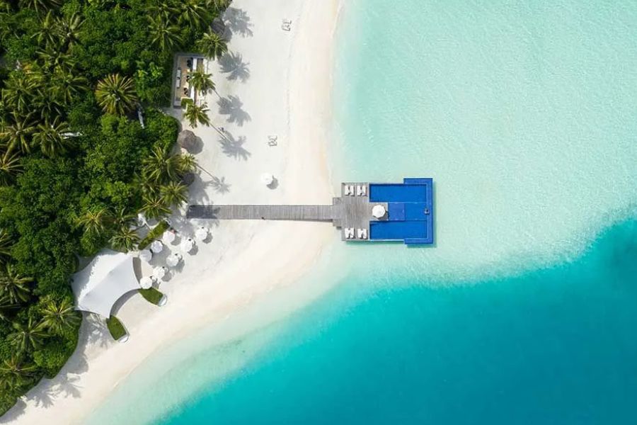 Aerial view of a beachfront overwater platform with a pool, Maldives