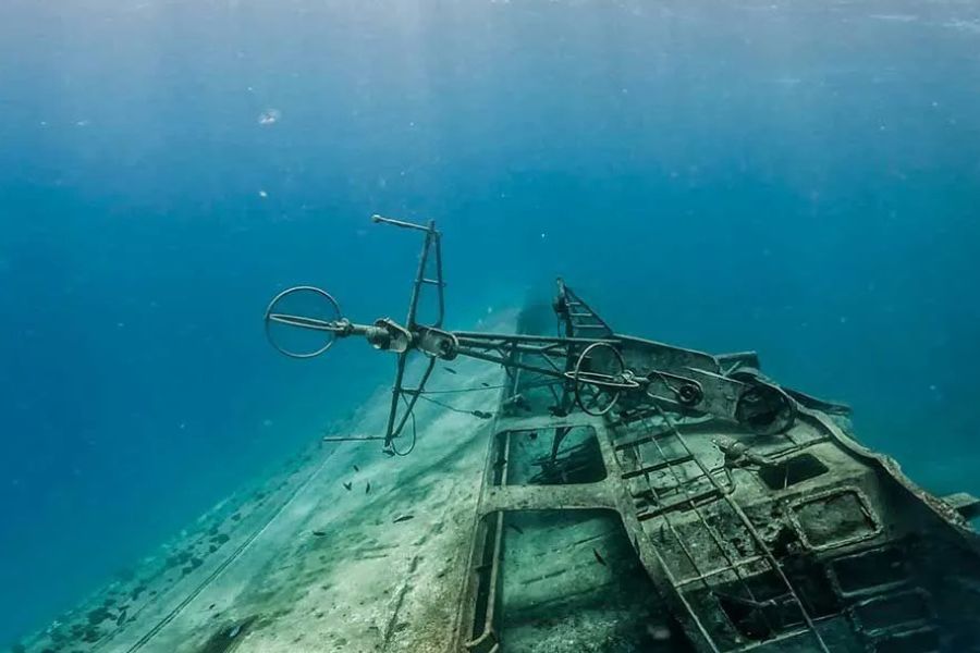 Underwater shipwreck dive site with visible mast and structure in the Maldives
