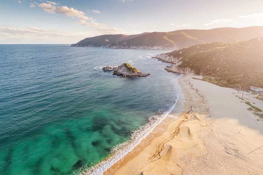 Aerial view of a scenic beach and mountainous coastline on Réunion Island.
