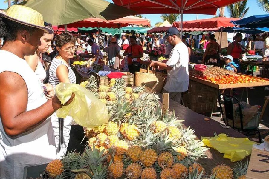Local market in Réunion Island with fresh pineapples and tropical produce.