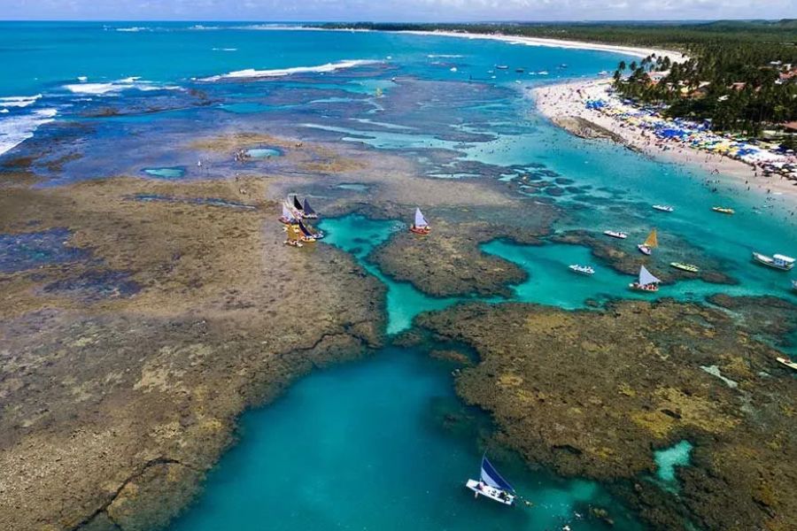 Coral reefs, sailing boats and a tropical beach along Mozambique’s coastline.