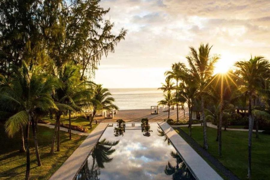 Sunrise over a luxury beachfront resort with an infinity pool in Mauritius.