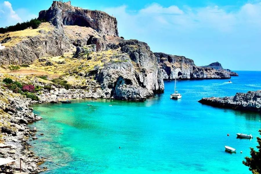 Lindos Acropolis overlooking a turquoise bay on Rhodes, Greece.