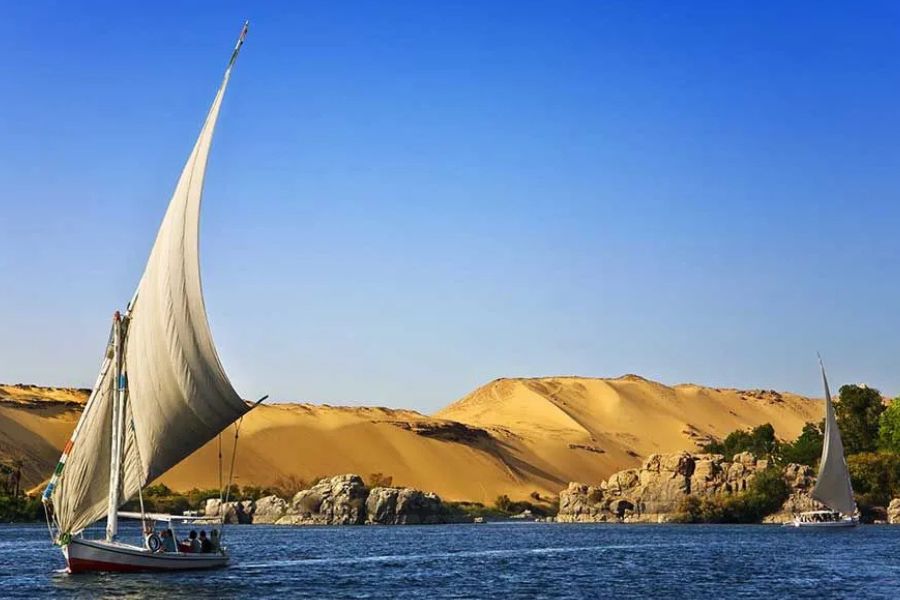 Traditional felucca sailing on the Nile River near Aswan, Egypt.