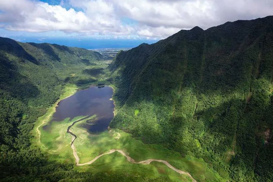 Aerial view of a lush volcanic valley and crater lake on Réunion Island