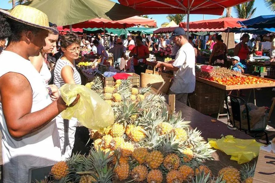 Local Réunion Island market with fresh pineapples and tropical produce.