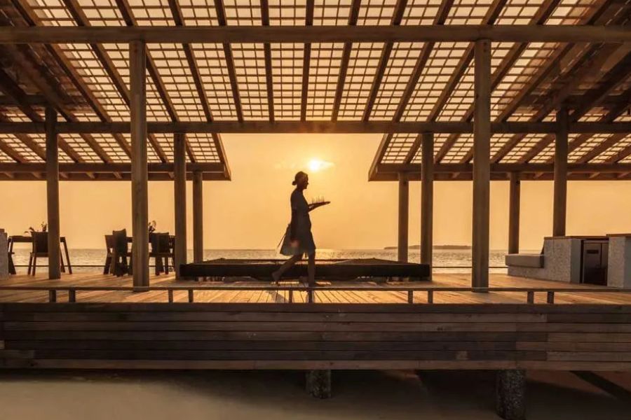 Sunset dining service at a luxury beachfront resort in the Maldives.