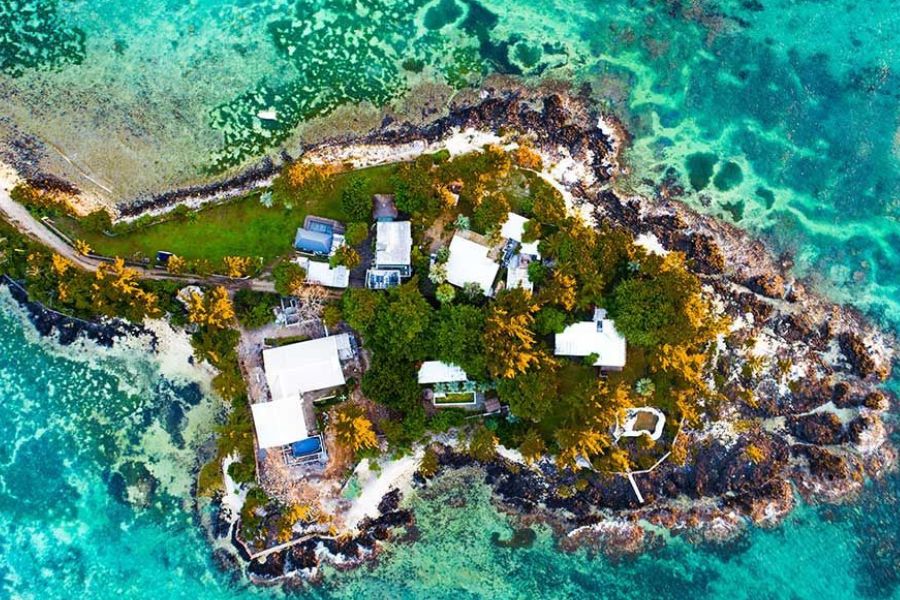 Aerial view of a private island resort surrounded by Mauritius’ turquoise lagoon.