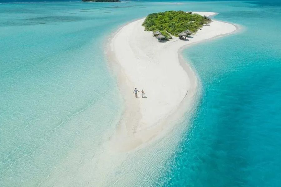 Aerial view of a pristine Maldives sandbank surrounded by turquoise water.