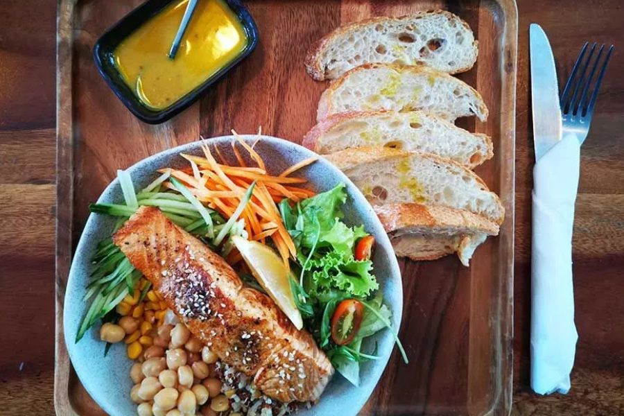 Grilled salmon salad with fresh vegetables and artisan bread.