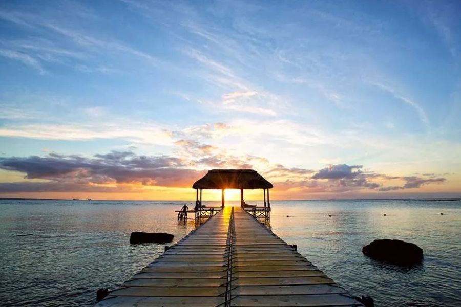 Sunset over a peaceful jetty and lagoon in Mauritius.