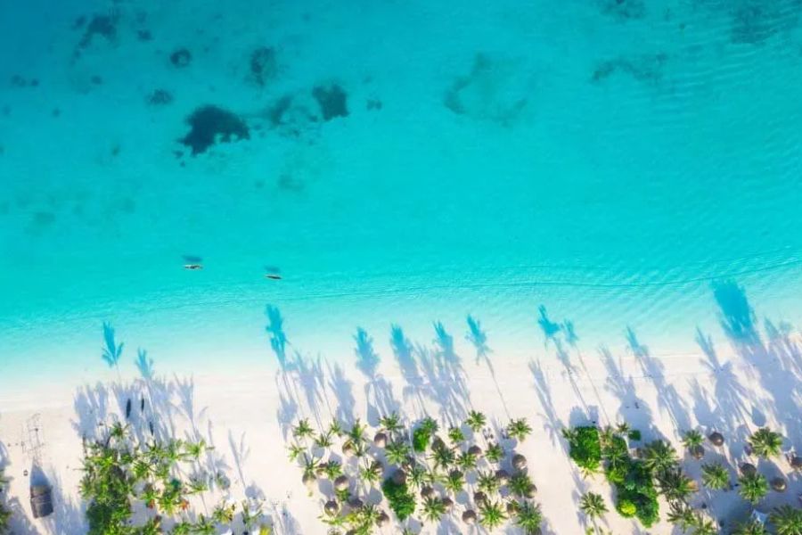 Aerial view of Zanzibar’s white-sand beach and clear turquoise lagoon.