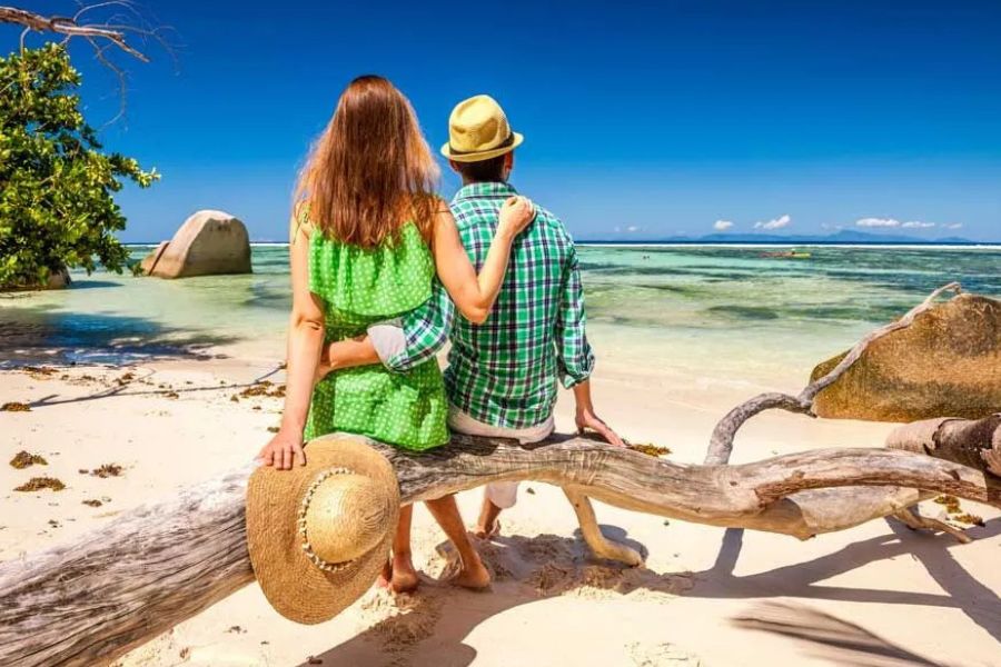 Couple enjoying a peaceful tropical beach in the Seychelles.