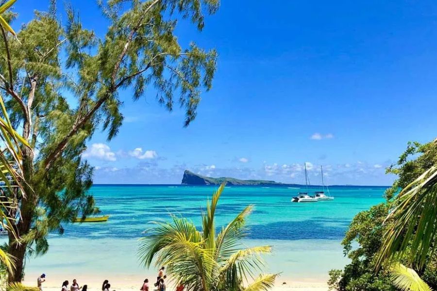 Turquoise lagoon and Coin de Mire views from a tropical beach in Mauritius.