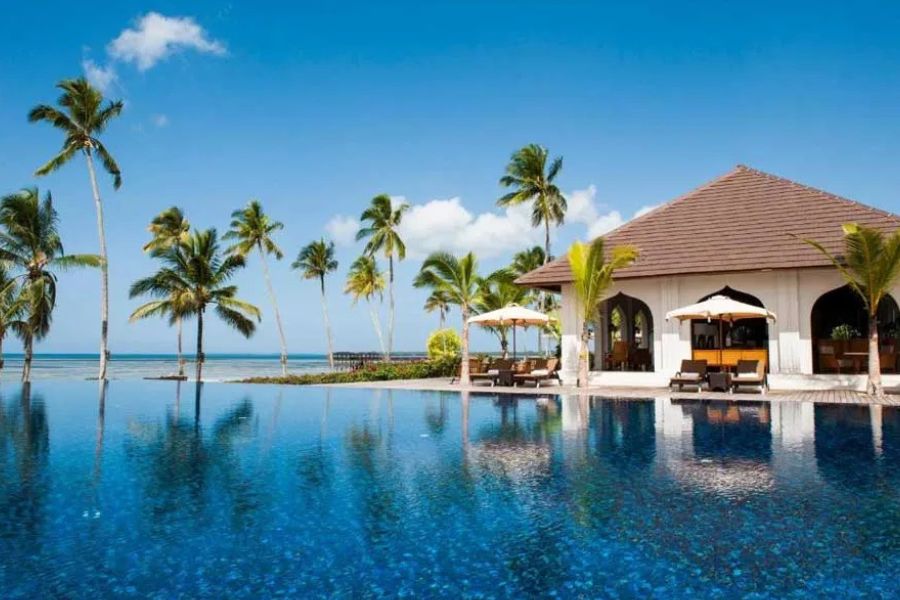 Infinity pool at a tropical resort with sun loungers and ocean views