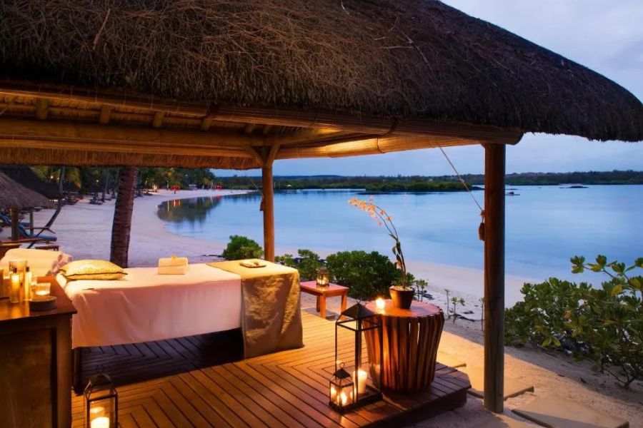 Outdoor beach spa gazebo with massage table and candles overlooking the ocean