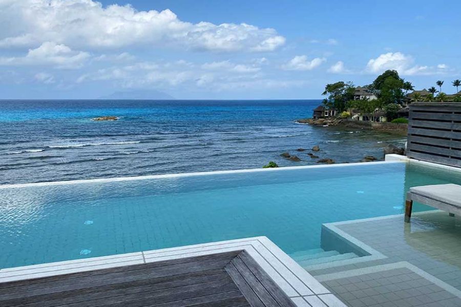 Private infinity pool overlooking a deep blue ocean with distant island view