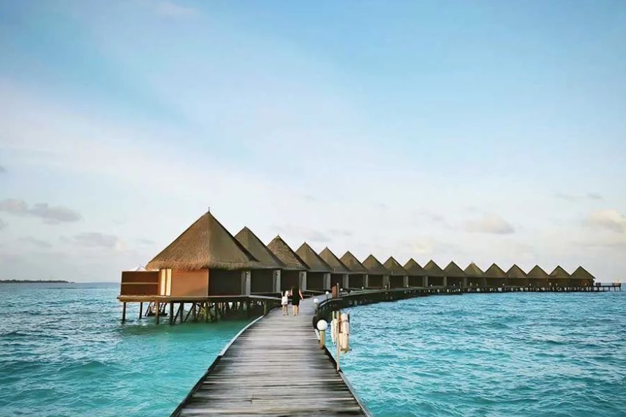 Wooden jetty walkway leading to overwater bungalows in a tropical resort