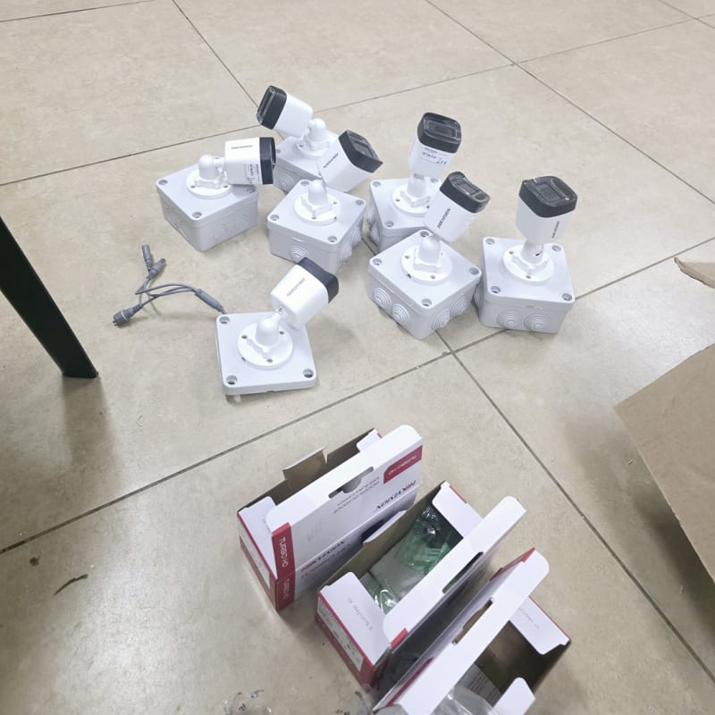 Preparing Hikvision CCTV cameras and mounting boxes for installation around the property.