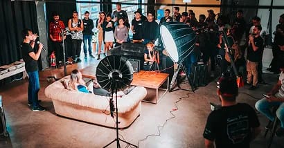 Wedding couple kissing on church steps surrounded by guests