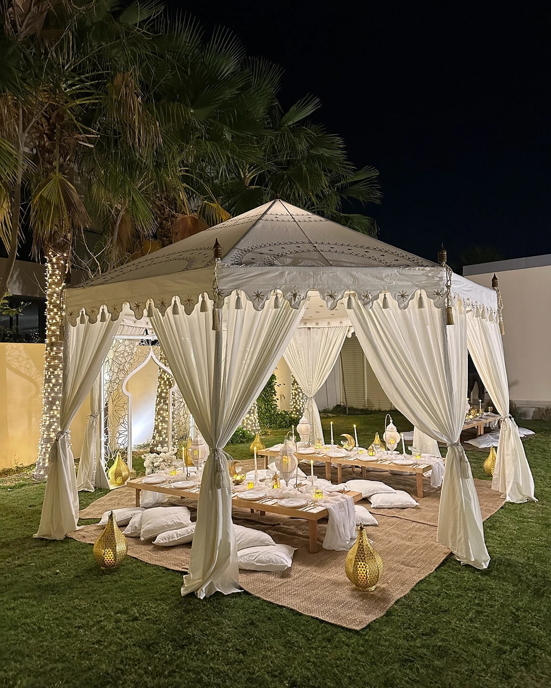 Luxury garden cabana dinner setup with soft drapes, cushions and intimate lighting for private events