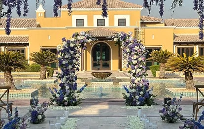 Wedding couple kissing on church steps surrounded by guests