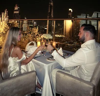 Close-up of couple holding hands in traditional wedding attire with bouquet