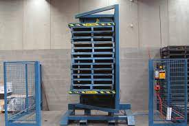 Industrial pallet handling equipment showing a pallet changer in action.