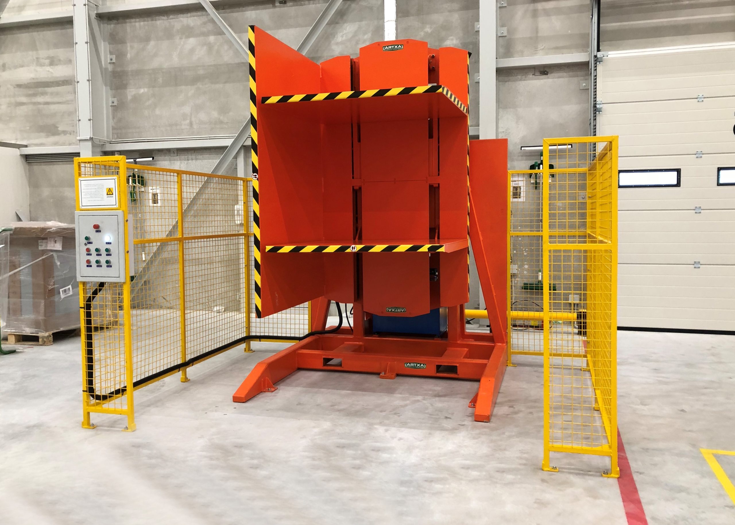 Engineers overseeing the installation of a new pallet changer machine on a factory floor.