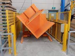 A mobile or portable pallet inverter being used in a busy warehouse setting