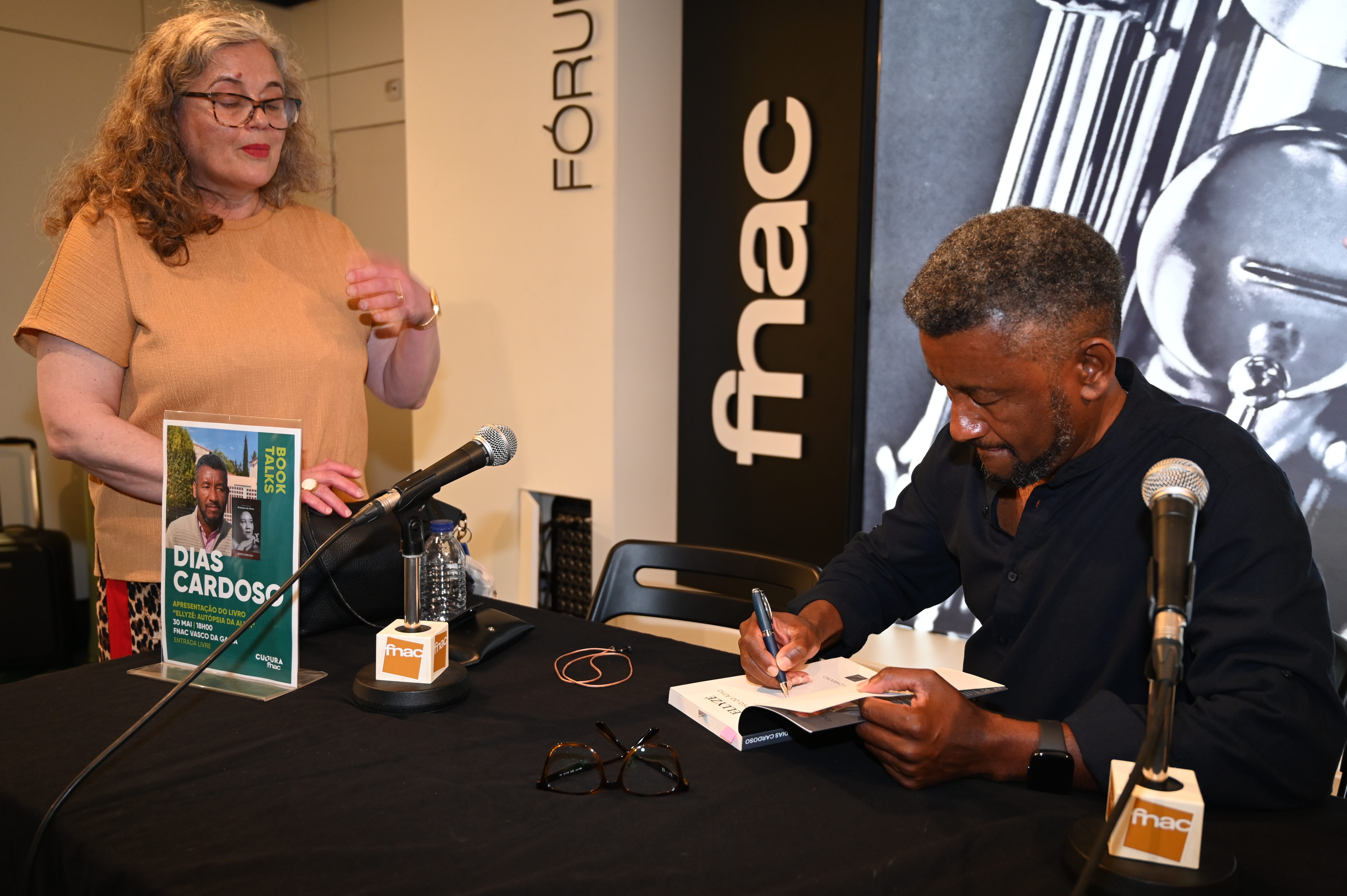 Autor autografando o livro para a Paula Amaro, diretora da Dinalivro