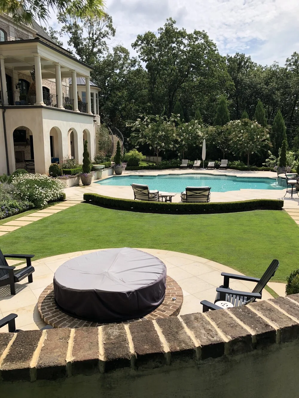 Maintained lawn and plant beds beside a pool