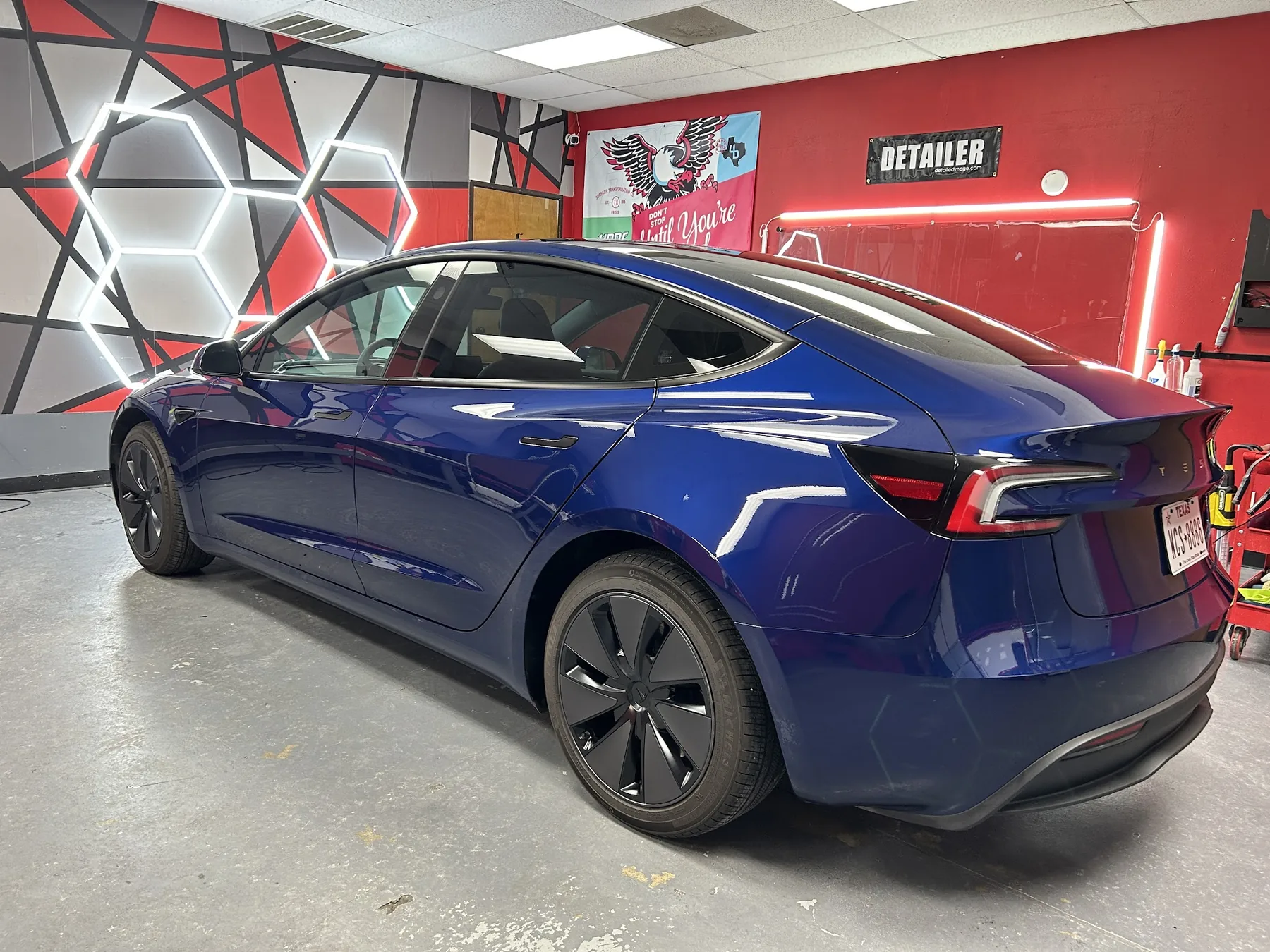 Blue Tesla Model 3 receiving premium ceramic window tint in Dallas shop