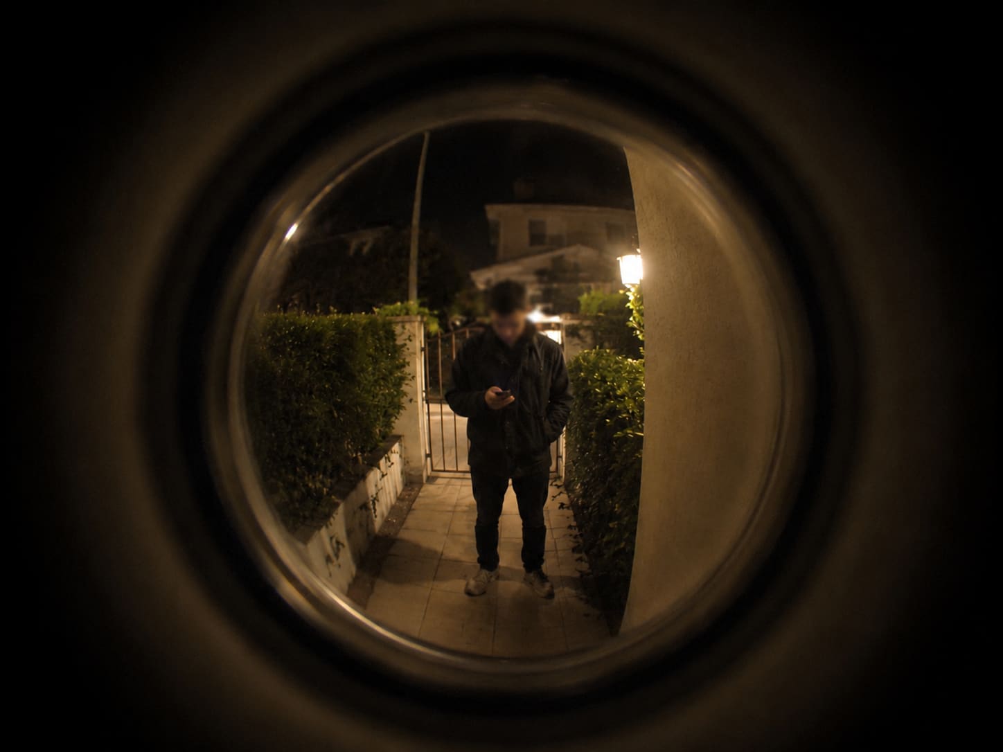 POV looking at an apartment front door at night with low warm light
