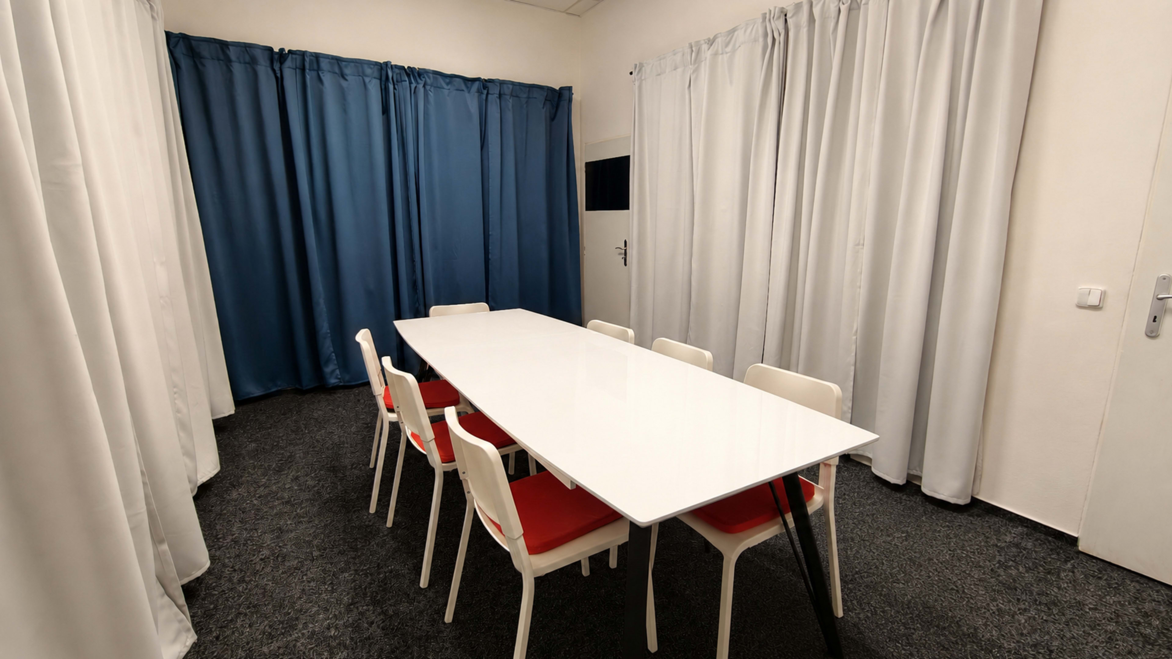 Private meeting room with a long table and curtains