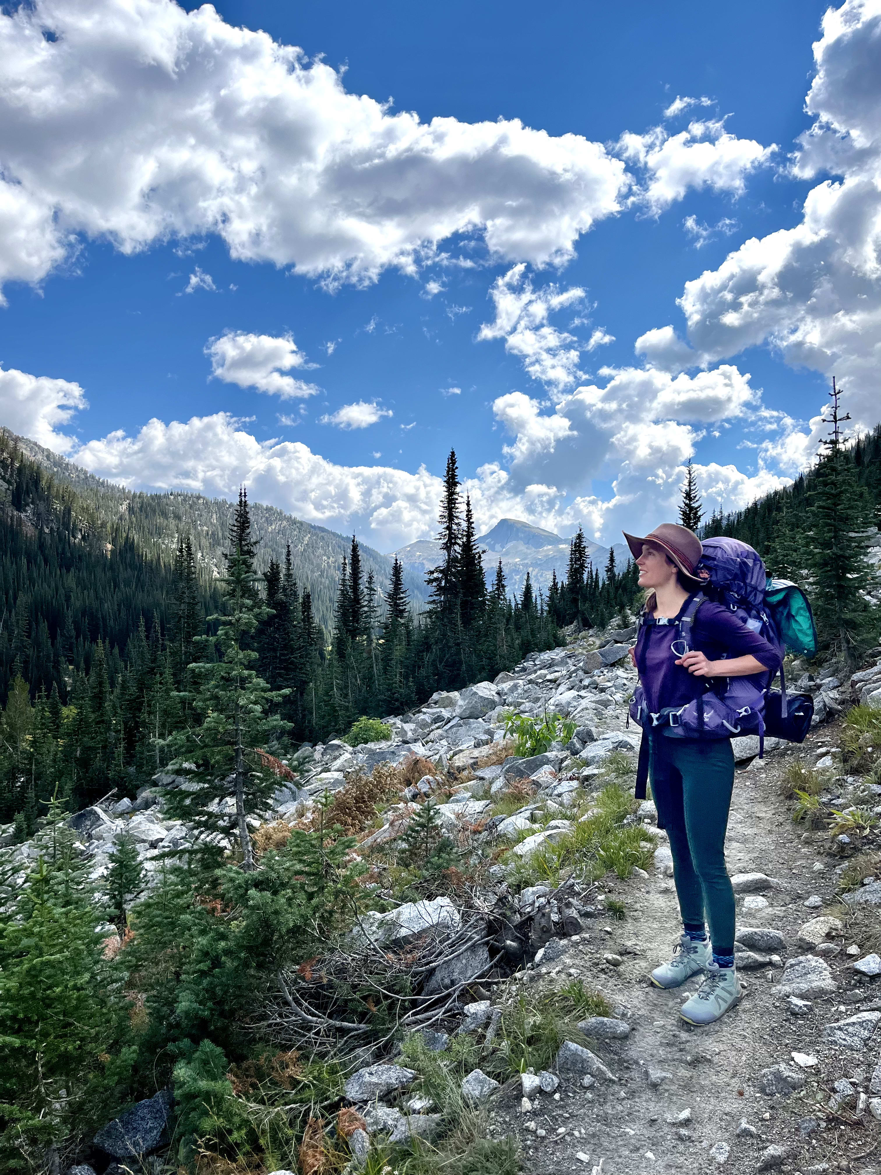 Amanda backpacking and smiling on a trail