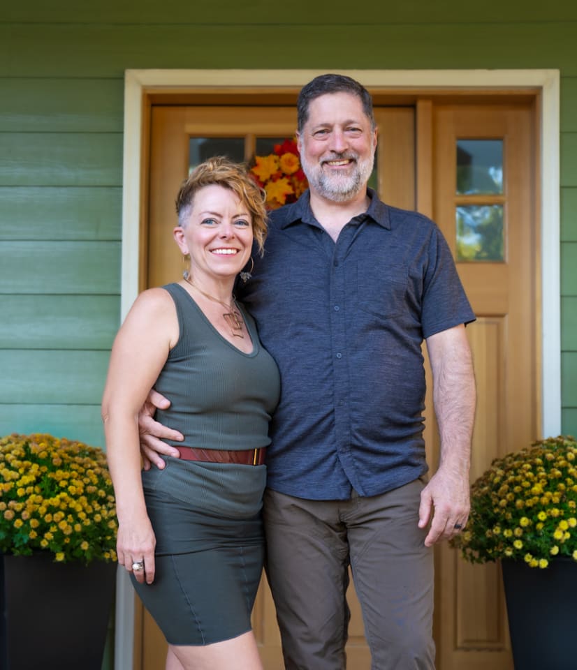 Family smiling on their doorstep during a lifestyle photography session in Bend