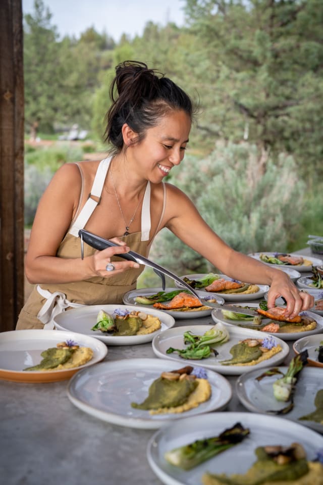 Chef smiling while serving dinner at an event in Bend, Oregon