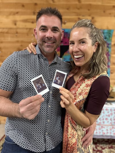 Happy couple holding Polaroid photos at an event
