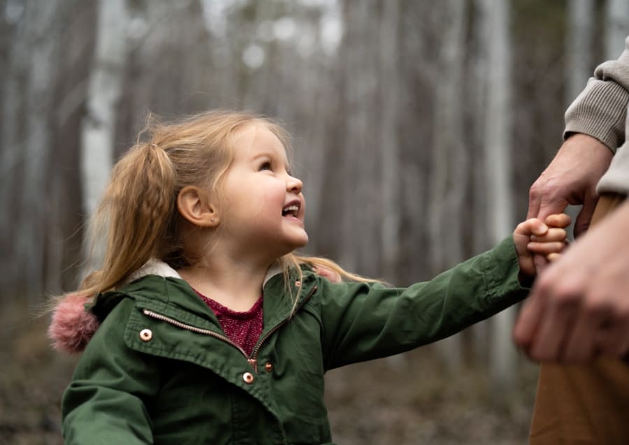 Child smiling with dad during a Wild Play Photography family session in Bend, Oregon