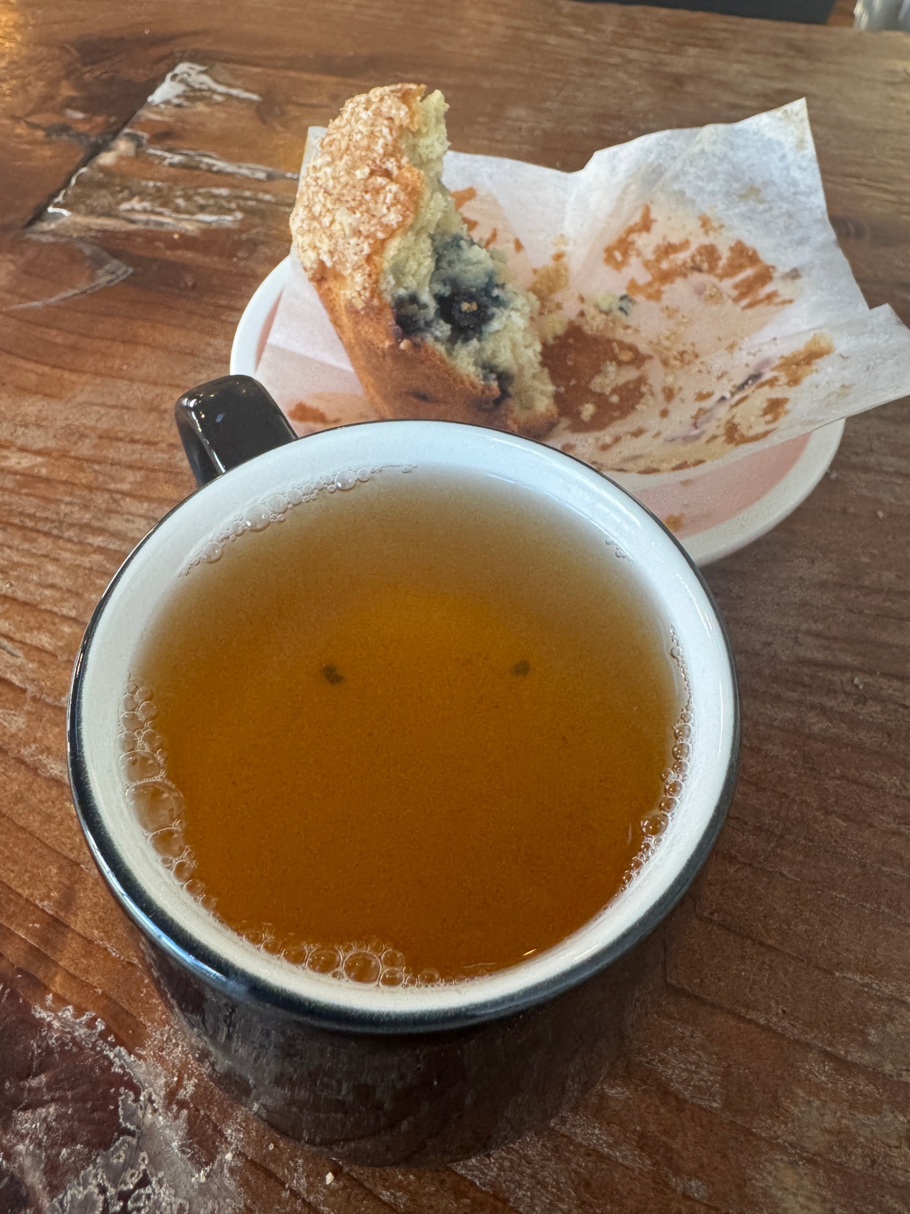 jasmine tea with a absolutely DEVOURED blueberry muffin in the background